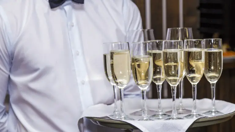 Ein Kellner bedient die Gäste mit Champagnergläsern während eines Business-Events.