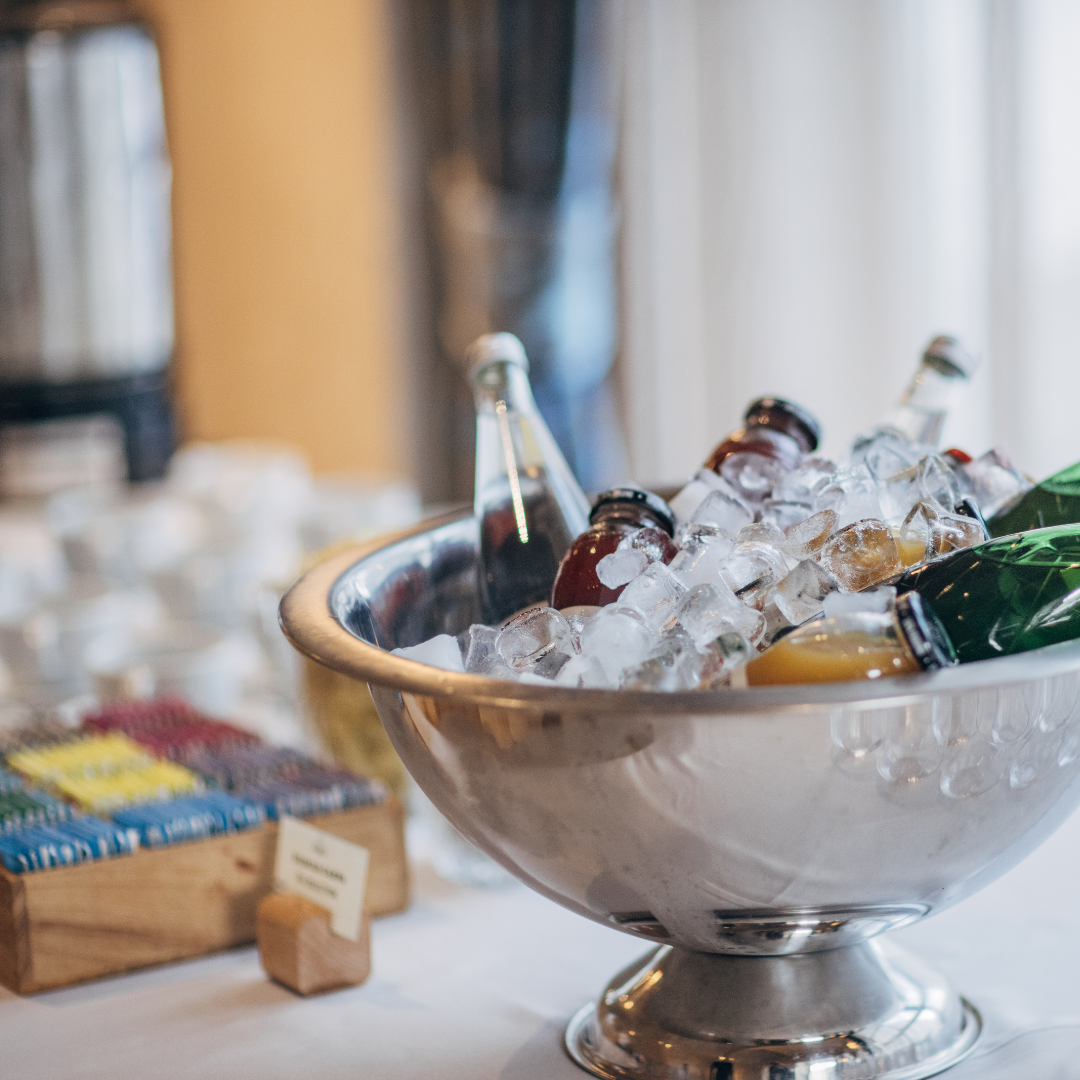 Aufgestellte Tassen, Tee und in Eis gekühlte Softdrinks auf einem Event-Buffet.
